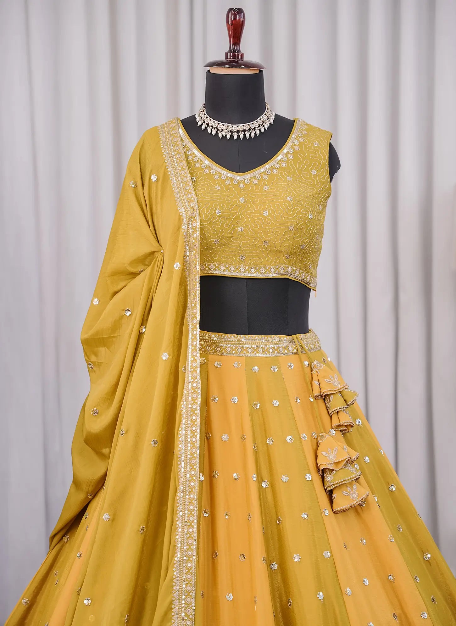 Close-up of embroidered blouse design in mustard yellow Fendi silk lehenga choli
