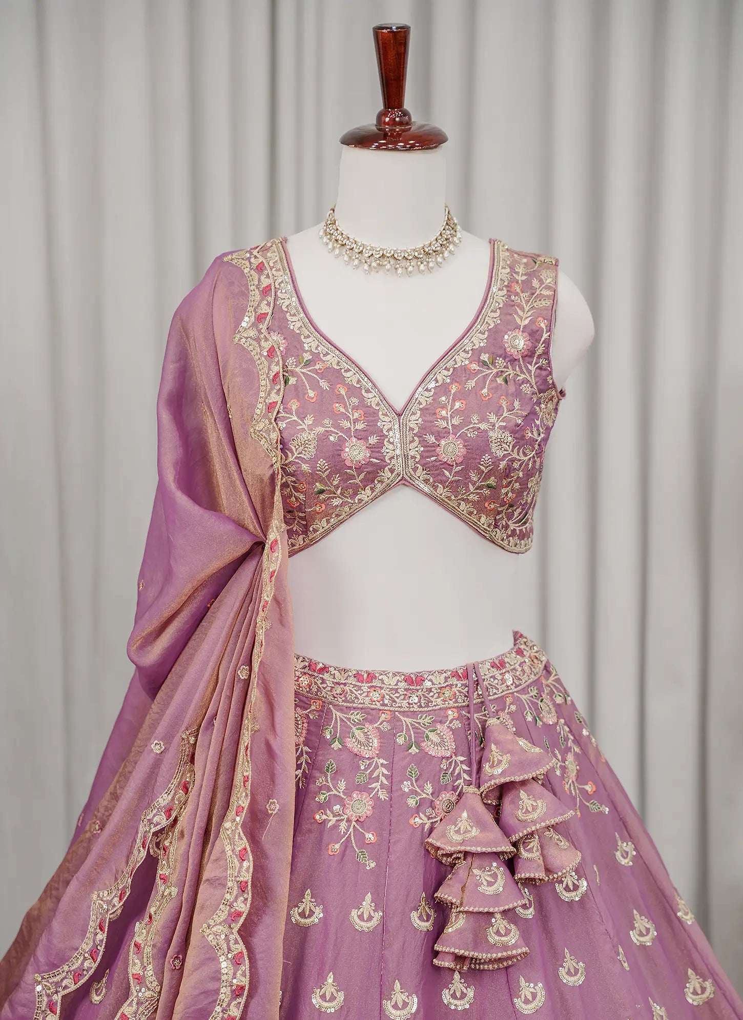 Close-up embroidery work on pink wedding lehenga choli fabric
