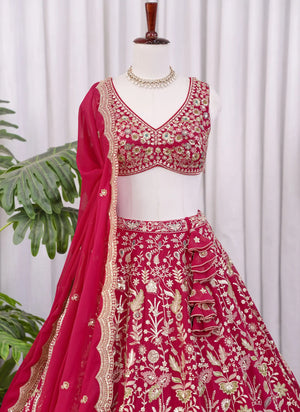 Close-up detail of heavy floral embroidery work on Rani pink lehenga choli fabric