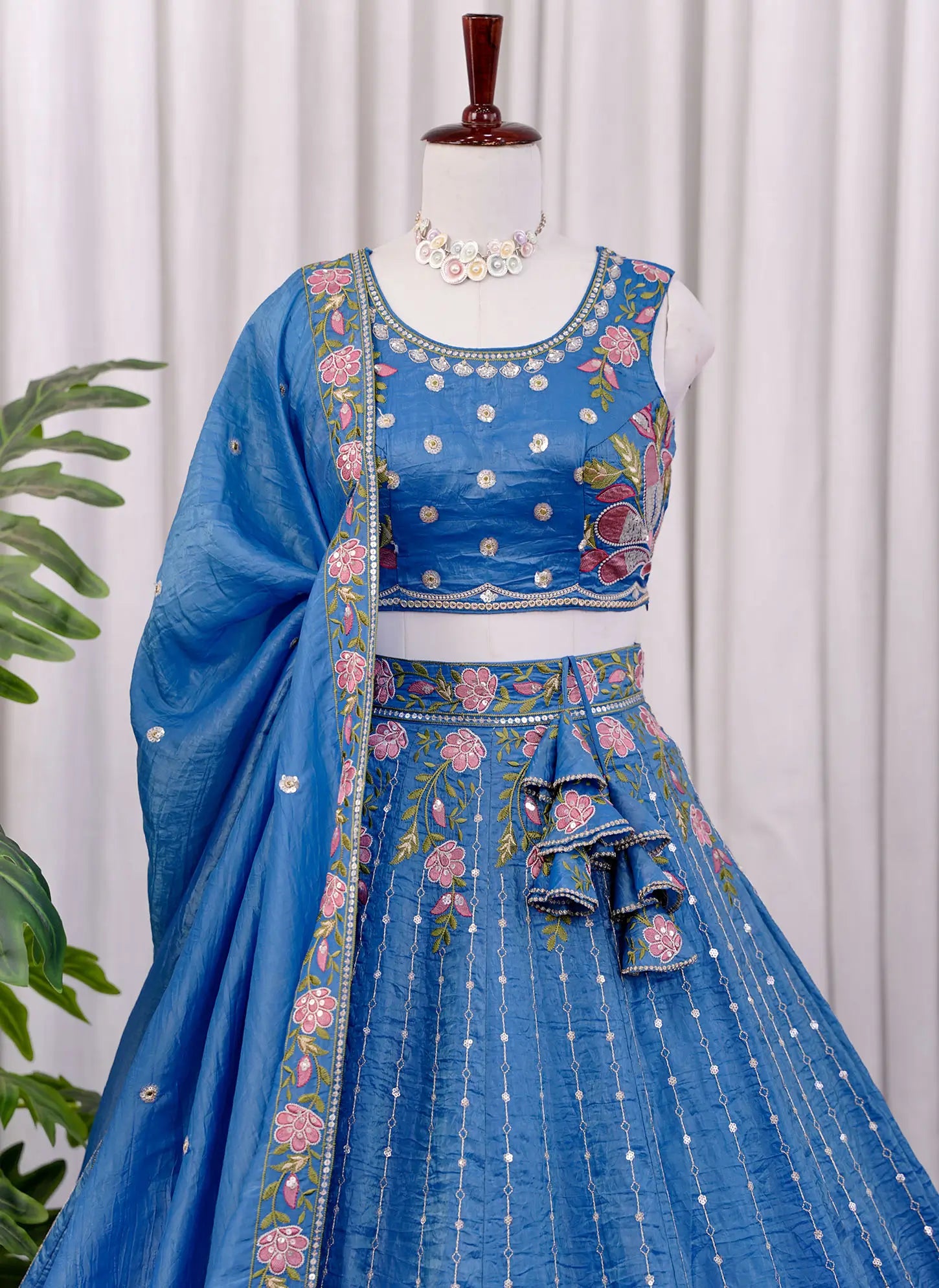 Close-up of floral embroidery work on sky blue lehenga choli fabric