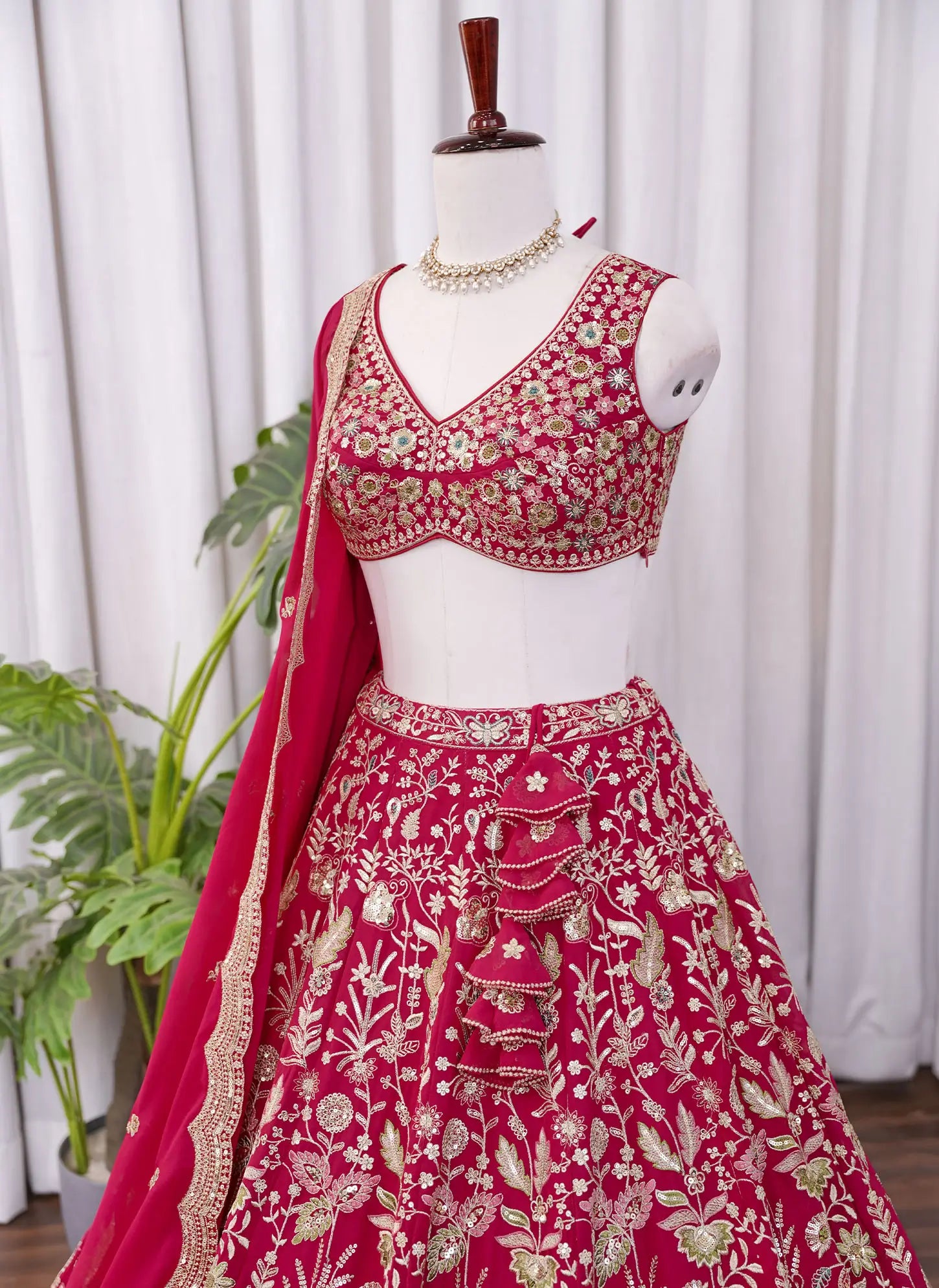 Left side view of Rani pink lehenga choli with intricate heavy floral embroidery work